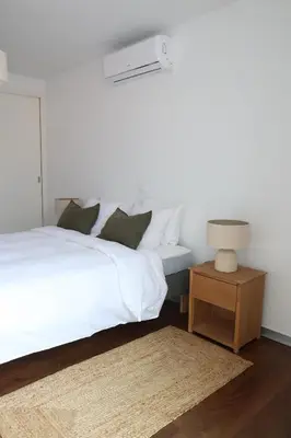 a bedroom with a white bed and a table with a lamp at Heart of Funchal 4 BD Apartment - Casa d Alma in Funchal