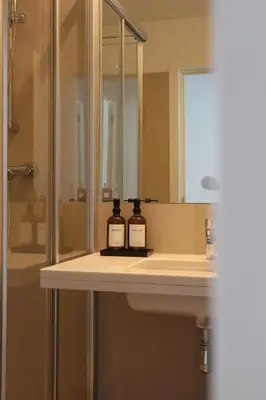 a bathroom with a sink with two bottles on it at Heart of Funchal 4 BD Apartment - Casa d Alma in Funchal