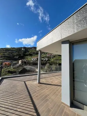 a building with a balcony with a view of a city at Sunset Valley House in Ribeira Brava