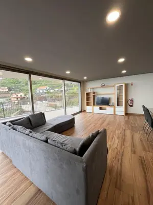 a large living room with a couch and a large window at Sunset Valley House in Ribeira Brava