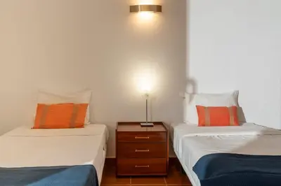 a bedroom with two beds and a nightstand between them at Casa do Ribeiro Salgado II by An Island Apart in Porto Santo