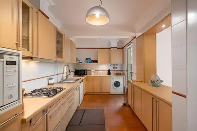 a kitchen with wooden cabinets and a washer and dryer at Casa do Ribeiro Salgado II by An Island Apart in Porto Santo