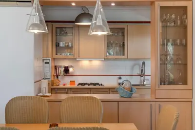 a kitchen with wooden cabinets and a table with chairs at Casa do Ribeiro Salgado II by An Island Apart in Porto Santo