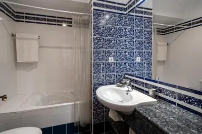 a blue and white bathroom with a sink and a tub at Casa do Ribeiro Salgado II by An Island Apart in Porto Santo
