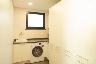 a laundry room with a washing machine and a window at Villa Eden Nature in Prazeres in Prazeres