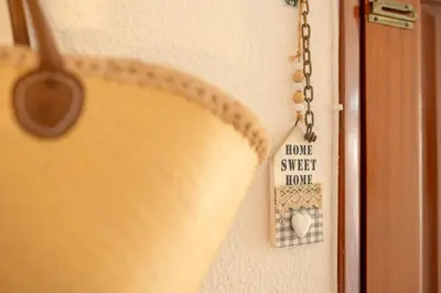 a close up of a door with a sign on a chain at Casa das Rosas in Funchal