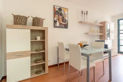 a dining room with a glass table and white chairs at Casa das Rosas in Funchal