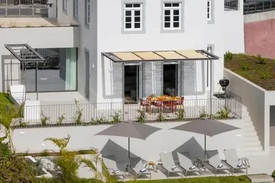 a villa with a swimming pool and a view of the ocean at MemorHia Village by OurMadeira in Calheta