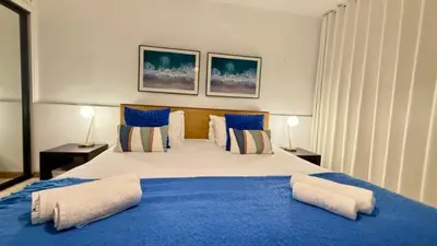 a bedroom with a large bed with blue sheets and pillows at Sea Haven in Funchal