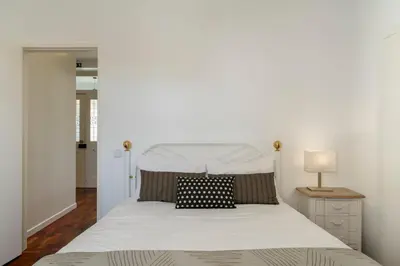 a bedroom with a white bed with a white headboard at Casa do Beiral by An Island Apart in Santa Cruz