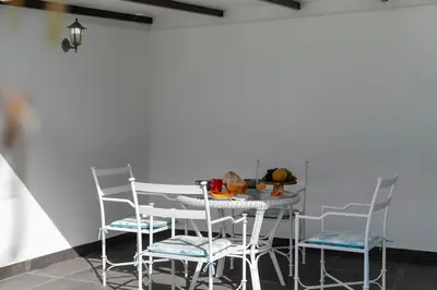 a table and chairs in a room with a white wall at Casa do Beiral by An Island Apart in Santa Cruz