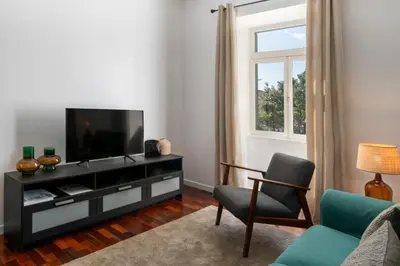 a living room with a television and a chair at Casa do Beiral by An Island Apart in Santa Cruz