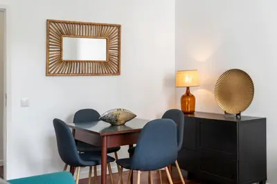a dining room table with chairs and a mirror at Casa do Beiral by An Island Apart in Santa Cruz