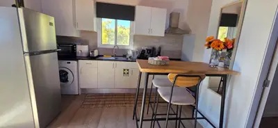a living room with a flat screen tv on a stand at Chalet Abacates in Estreito da Calheta