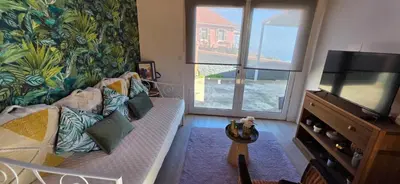 a living room with a flat screen tv on a stand at Chalet Abacates in Estreito da Calheta