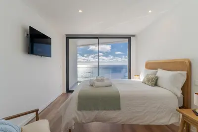 a bedroom with a large bed with a large window at Atlantic Heights Varandas do Atlântico by Holiday Rental Madeira in Câmara de Lobos