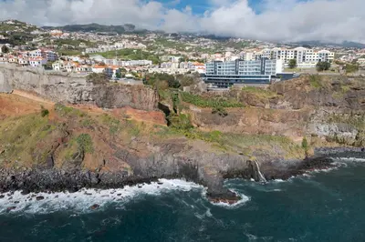 a city on top of a cliff next to the ocean at Atlantic Heights Varandas do Atlântico by Holiday Rental Madeira in Câmara de Lobos
