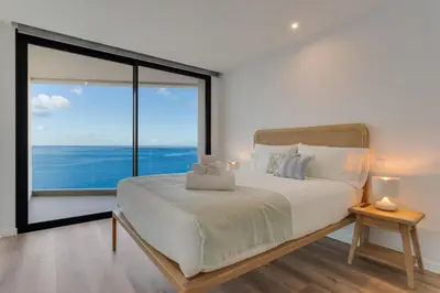 a bedroom with a large bed with a large window at Atlantic Heights Varandas do Atlântico by Holiday Rental Madeira in Câmara de Lobos