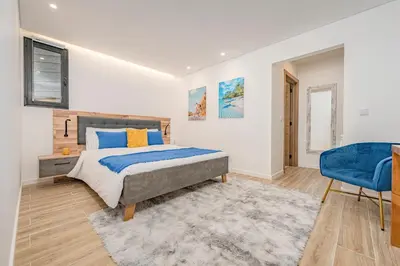 a bedroom with a bed and a blue chair at Oxford apartment Alpine escape villa in Gaula