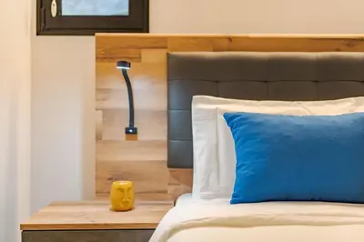 a bedroom with a bed with a blue pillow and a lamp at Oxford apartment Alpine escape villa in Gaula
