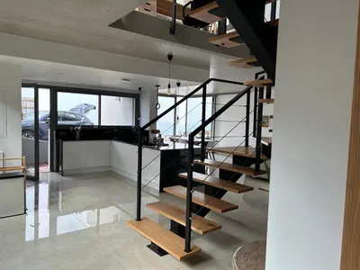 a modern house with a black staircase in a room at Villa MARIE in Fajã da Ovelha