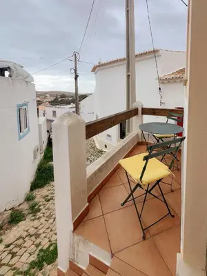 a small balcony with a table and chairs on it at Casa Roma in Raposeira