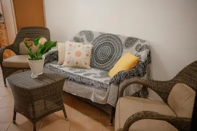 a living room with a couch and chairs and a vase of flowers at Casa Roma in Raposeira