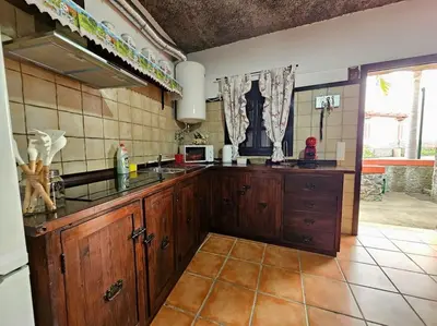 a kitchen with wooden cabinets and a counter top at Refugio Jardim Prazeres WiFi BBQ in Prazeres