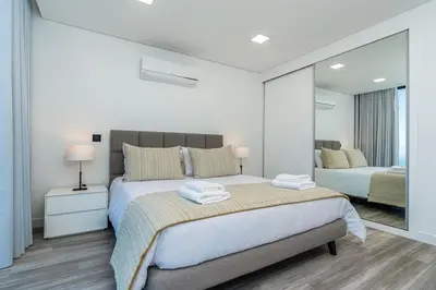 a white bedroom with a large bed and a mirror at Villa Lunarenzo seaview, Pool, AC, parking in Calheta