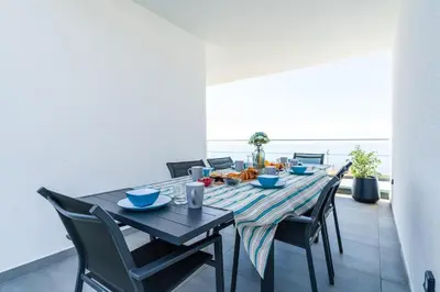 a dining room with a long table and chairs at Villa Lunarenzo seaview, Pool, AC, parking in Calheta