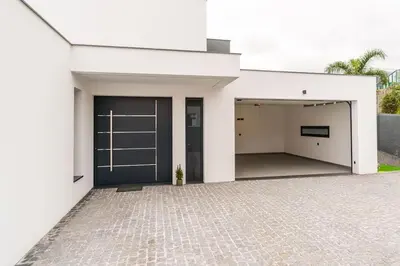a white building with a garage with a door at Villa Lunarenzo seaview, Pool, AC, parking in Calheta