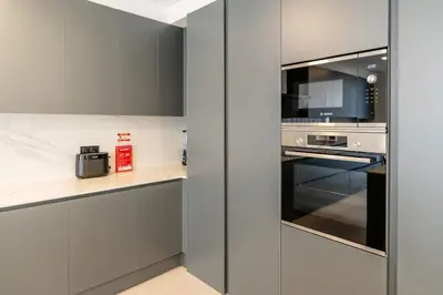 a kitchen with gray cabinets and a microwave at Villa Lunarenzo seaview, Pool, AC, parking in Calheta