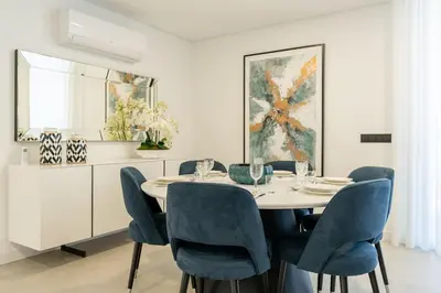a dining room with a table and blue chairs at Villa Lunarenzo seaview, Pool, AC, parking in Calheta