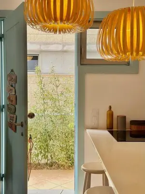 a kitchen with a yellow chandelier and a kitchen table at Casa Bamboo in Porto Santo