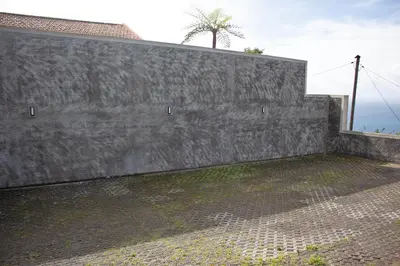 a concrete wall with a palm tree in the background at Atlantic View Residence in Funchal