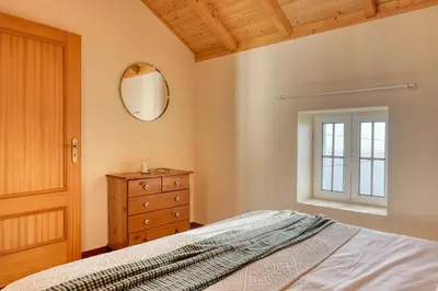 a bedroom with a bed and a mirror and a dresser at Ocean View Cottage a Home in Madeira in Fajã da Ovelha