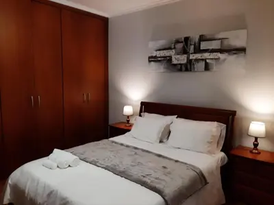 a bedroom with a bed with white sheets and two lamps at Paradise Valley Ribeira Brava in Ribeira Brava