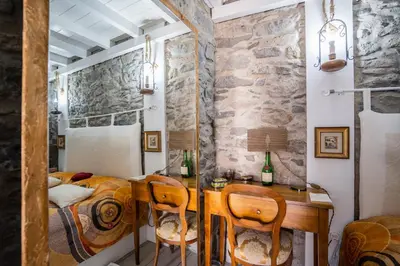 a bedroom with a desk and a bed and a stone wall at Casa Neverland in Vila Baleira