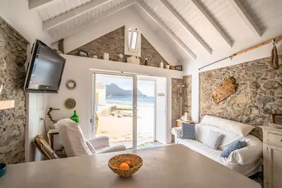 a living room with a table and a view of the ocean at Casa Neverland in Vila Baleira