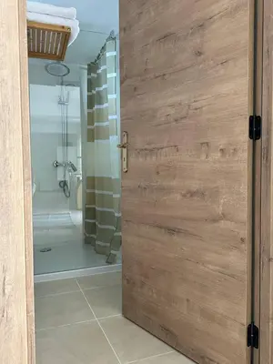 a bathroom with a wooden door with a shower at Taverna in São Jorge