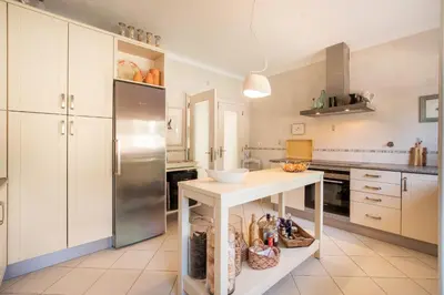 a kitchen with a refrigerator and a table in it at 804 Quinta Felicidade in Lagos