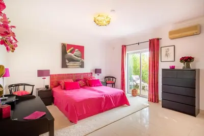 a bedroom with a pink bed and a desk at 804 Quinta Felicidade in Lagos