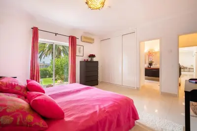 a bedroom with a pink bed and a bathroom at 804 Quinta Felicidade in Lagos