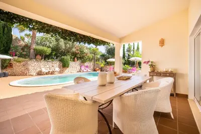 a dining room with a table and chairs and a swimming pool at 804 Quinta Felicidade in Lagos