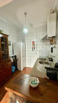 a kitchen with a white refrigerator and a table at Casa do Careca in Sagres