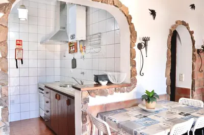a kitchen with a sink and a table in a room at Casa do Careca in Sagres