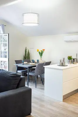 a kitchen and living room with a table and chairs at Panoramic Attic by Sabugo House in Relógio do Poiso