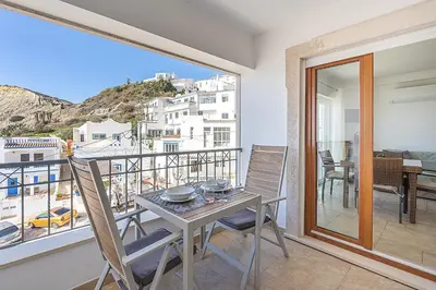 a dining room with a table and chairs on a balcony at Beach Apt 1 In Burgau in Burgau