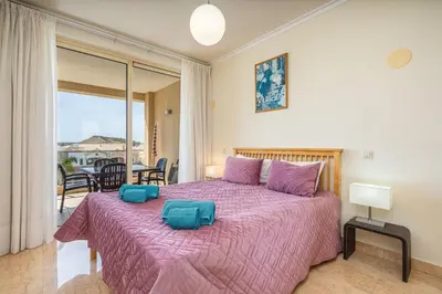 a bedroom with a large bed with a purple blanket at Apt Brightness Comfort In Burgau in Burgau