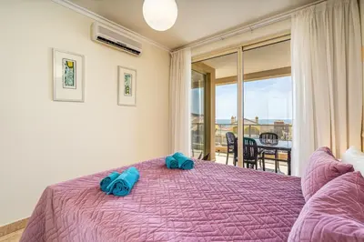 two beds in a room with two windows at Apt Brightness Comfort In Burgau in Burgau